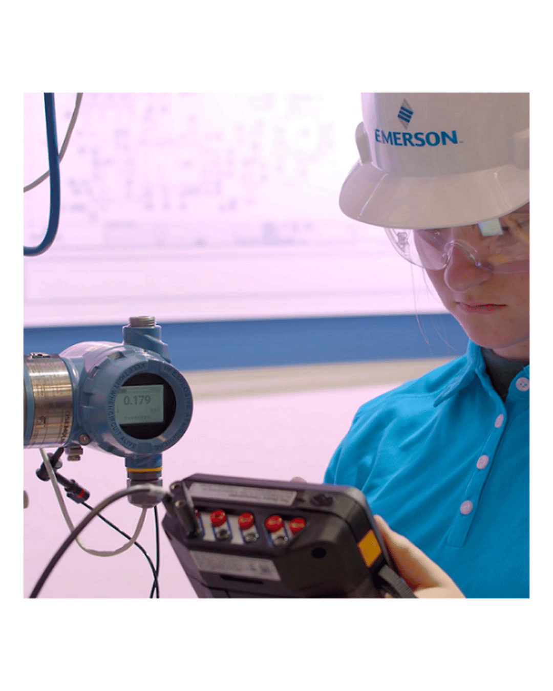 Technician operating Emerson AMS Trex communicator in field to test process transmitter
