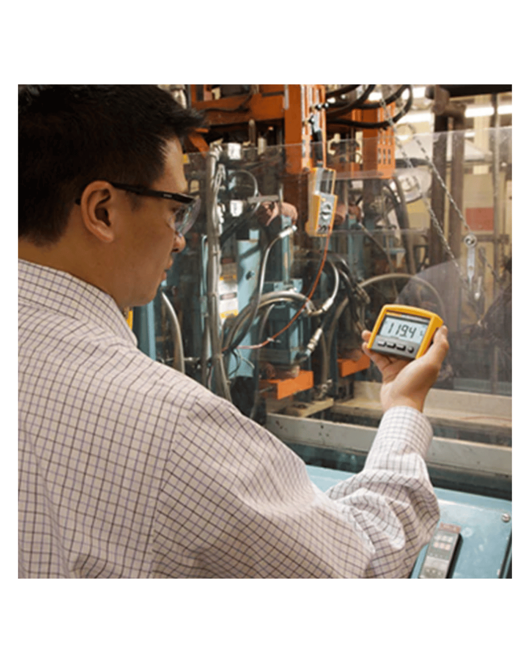 Operator remotely reading Fluke 233 digital multimeter display during live measurement